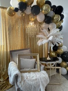 a room filled with balloons and chairs next to a gold drape curtain covered wall