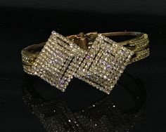 Stunning vintage crystal statement bangle in fantastic condition. This hinged gold  tone bracelet should fit most wrist sizes. Rows of sparkling prong set crystals in 3 d rectangular pattern. Is much nicer than photos! Gift wrapped and ready to wear Glamorous Rhinestone Cuff Bracelet For Formal Occasions, Glamorous Crystal Cuff Bracelet For Formal Occasions, Dazzling Gold Crystal Bracelet For Formal Occasions, Gold Crystal Bangle For Formal Occasions, Formal Gold Crystal Bangle, Gold Crystal Cuff Bracelet Bangle, Gold Crystal Cuff Bracelet In Bangle Shape, Gold Crystal Bangle Cuff Bracelet, Formal Rhinestone Cuff Bangle Bracelet