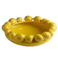 a yellow bowl with lemons in it on a white background