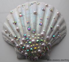 a close up of a seashell with pearls and sequins on the shell