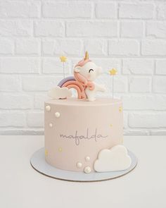 there is a pink cake with a unicorn on top and stars in the sky around it