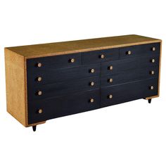 a black dresser with gold knobs on the top and bottom drawers, against a white background