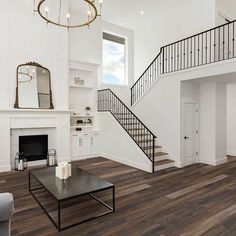 a living room filled with furniture and a fire place in front of a white wall