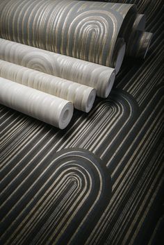 four rolls of wallpaper laying on top of each other in a room with black and white stripes