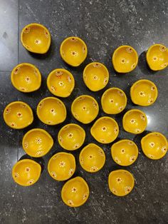 a bunch of yellow bowls sitting on top of a table next to each other in a circle