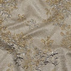 an image of a gold and silver fabric with flowers on the side, as seen from above