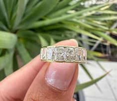 a woman's hand holding a ring that has three stones on the inside and outside