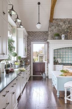 a large kitchen with white cabinets and wood flooring, along with an open door leading to the outside