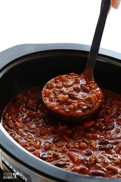 a spoon in a slow cooker filled with chili beans