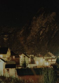 a night time view of some houses and mountains