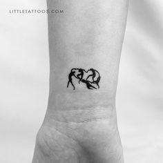 a small black and white tattoo on the wrist