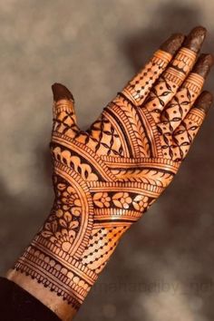 a person's hand with henna tattoos on it