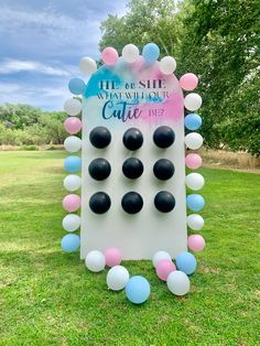 a giant board game is set up in the grass with balloons and confetti around it