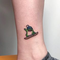 a small tattoo on the ankle of a person who is wearing a snowboarder