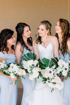 a group of women standing next to each other holding bouquets