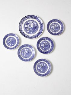 six blue and white plates sitting on top of a table