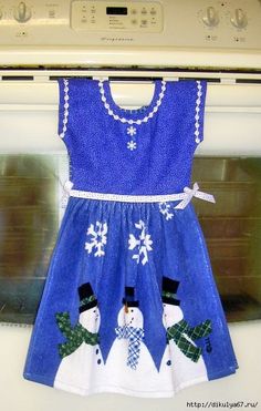 a blue dress with snowmen on it hanging from a dryer in the kitchen