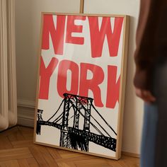 a sign that says new york on it in front of a person standing next to a wall