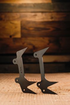 two pairs of scissors sitting on top of a wooden table