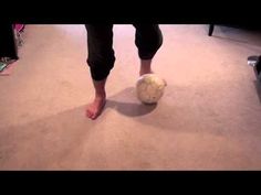 a person standing on the floor with a soccer ball in their hand and feet up