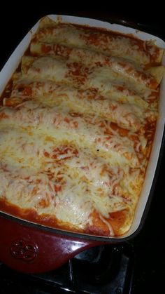 a casserole dish with cheese and meat in it sitting on the stove top