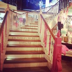 the stairs leading to victoria's secret upstairs are decorated with pink and white ribbons