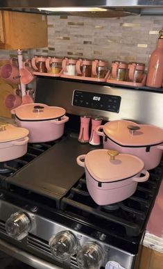 pink pots and pans are sitting on the stove