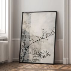 a black and white painting sitting on top of a wooden floor next to a radiator