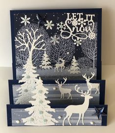 two christmas cards with deer and trees on them