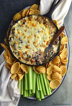 a plate with dip and chips on it