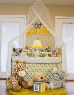 a baby crib with teddy bears and cakes on the table in front of it