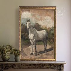 a white horse standing in front of a painting on a mantle next to a potted plant