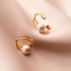 These exquisite ear clips offer the allure of pearls in a no-piercing design, meticulously crafted to adorn your ears with grace. The lustrous gold pearls rest snugly against the earlobe, creating a touch of sophistication without the need for piercings. Crafted with meticulous attention, they promise enduring brilliance and quality.Pearl size: 6mm925 Sterling Silver;18K Gold Plated;Nickel-free & Hypoallergenic. Elegant Clip-on Ear Cuff For Gift, Elegant Clip-on Ear Cuff Gift, Gold Pearl Ear Cuff Gift, Gold Pearl Ear Cuff As A Gift, Elegant Gold Clip-on Ear Cuff, Elegant Rose Gold Ear Cuff, Elegant Gold Ear Cuff With Pearl Drop, Ear Cuff Jewelry, Bridal Clip