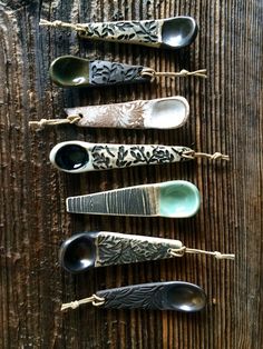 five spoons are lined up on a wooden surface