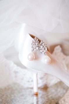 the bride's wedding shoes are adorned with pearls