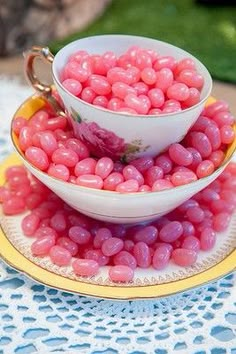 two bowls filled with pink candy on top of a yellow plate