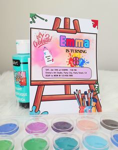 an artist's kit with paints and watercolors on a white surface next to it