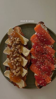 two pieces of toast with fruit and nuts on them, sitting on a green plate