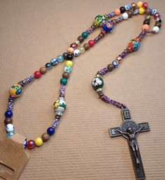 This rosary is made up of four strings that intertwine into what I call a rope. I cover this rope in 8-12 mm glass, acrylic, and/or wooden beads. I finish this master piece with a 2 inch Saint Benedict bronze or silver crucifix. This one reminded me of my mother all the colors throw back some memories, so i figured why not send it off for the day to celebrate Mothers Day! God Bless! Adjustable Crucifix Rosary, Adjustable Wooden Beads Spiritual Rosary, Bohemian Beaded Cross Rosary, Adjustable Crucifix Jewelry With Wooden Beads, Adjustable Wooden Bead Crucifix Jewelry, Adjustable Rosary With Large Beads As Gift, Adjustable Large Beads Rosary As Gift, Handmade Adjustable Bohemian Rosary, Adjustable Bohemian Rosary With Round Beads