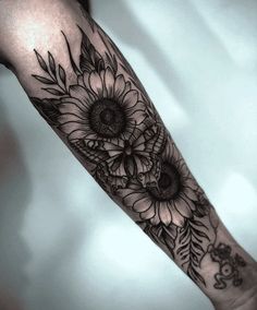 a woman's arm with sunflowers and leaves on it