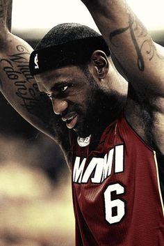 a close up of a basketball player with his arm in the air and tattoos on his body