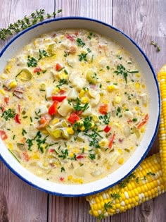 a white bowl filled with corn and cheese next to an ear of corn on the cob