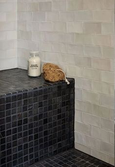 a black and white tiled bathroom with a bottle of milk on the counter next to it