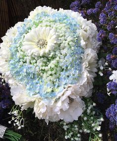 a large white and blue flower surrounded by purple flowers