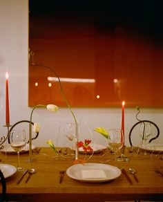 a wooden table topped with plates and glasses