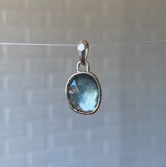 A silvery-blue freeform rose cut moss aquamarine is encased in sterling silver and hangs from a tapered, faceted bail.Chain sold separately. Shown on the model paired with a silver curb chain. You can view our chain options to add here: https://coreyegan.com/products/chain-silver Product Details 4.48ct Moss Aquamarine Pendant measures 7/8" L x 7/32" W sterling silver Bail opening is 3.3mm Pendant only. Chain sold separately. Silver Oval Apatite Jewelry, Silver Blue Topaz Briolette Jewelry, Silver Briolette Blue Topaz Jewelry, Silver Aquamarine Jewelry With Bezel Setting, Faceted Sapphire Silver Jewelry, Silver Teardrop Aquamarine Jewelry, Handmade Silver Jewelry With Green Amethyst, Silver Blue Topaz Oval Pendant Jewelry, Silver Oval Blue Topaz Pendant Jewelry