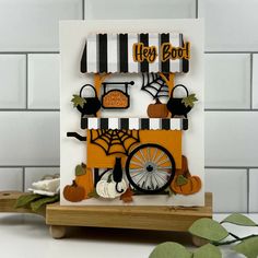 a halloween card with pumpkins and black and white stripes on it, including a bicycle