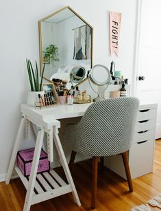 a white desk topped with a mirror next to a chair