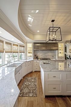 an instagramted photo of a kitchen with white cabinets and marble countertops,