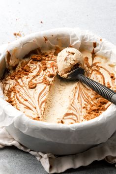 a bowl filled with ice cream sitting on top of a counter next to a spoon